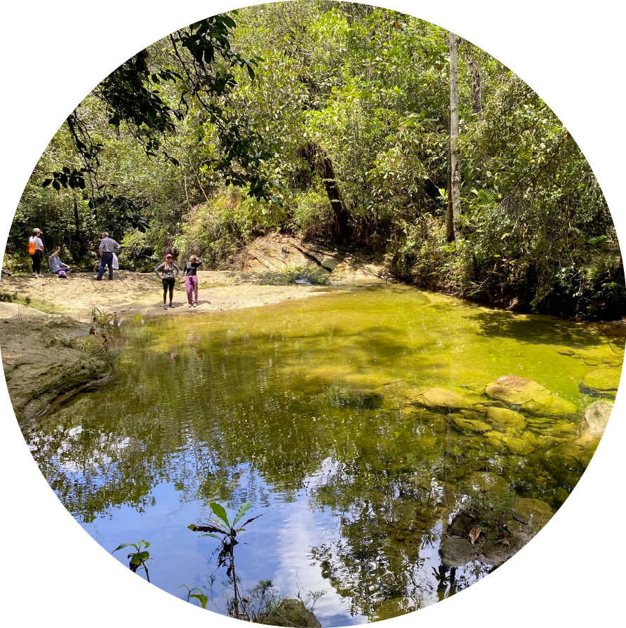 Salida de campo en paisaje natural, laguna en primer plano y de fondo estudiantes URosario